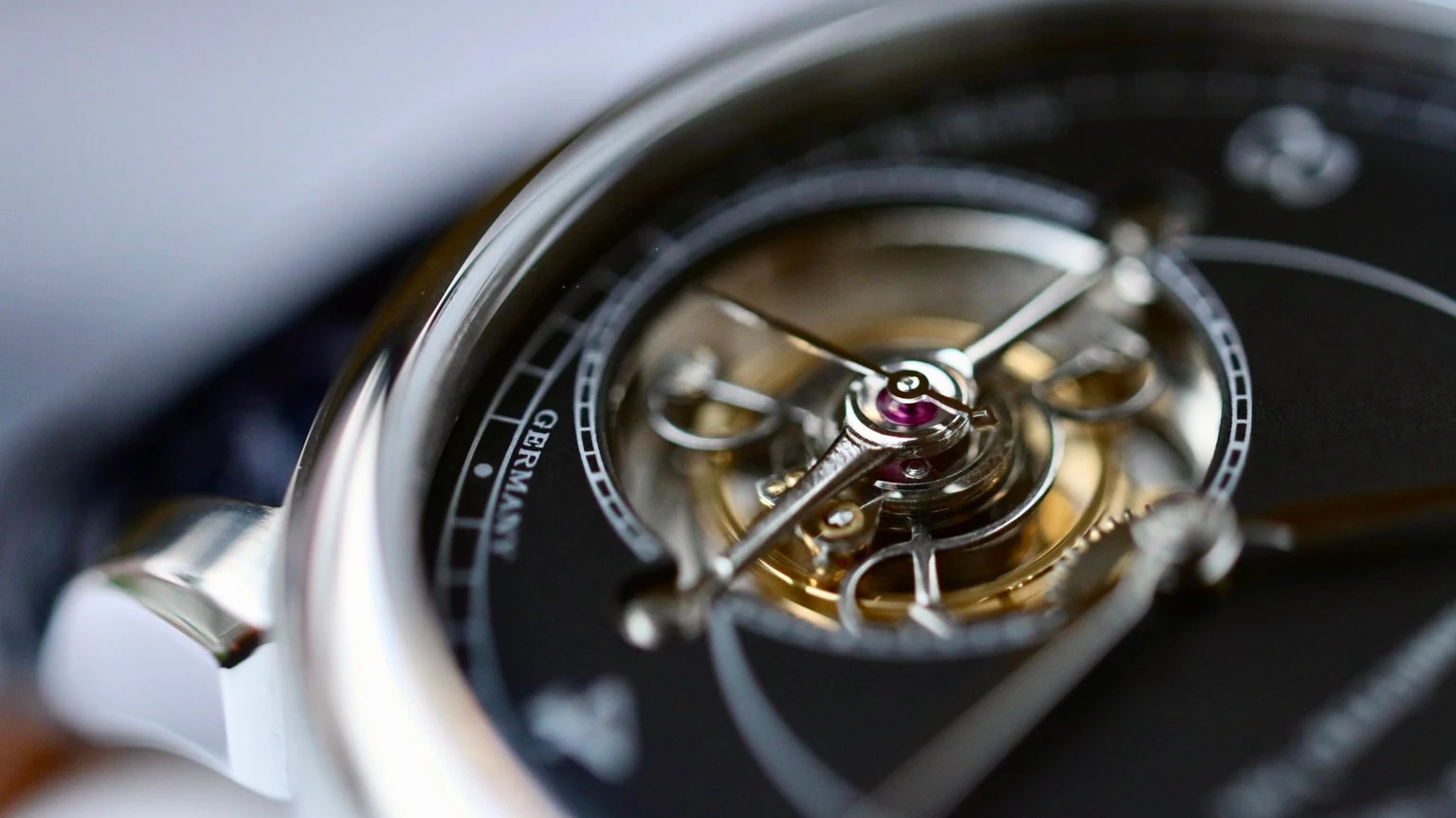 Macro view of a tourbillon assembly and its polished surrounding watch case