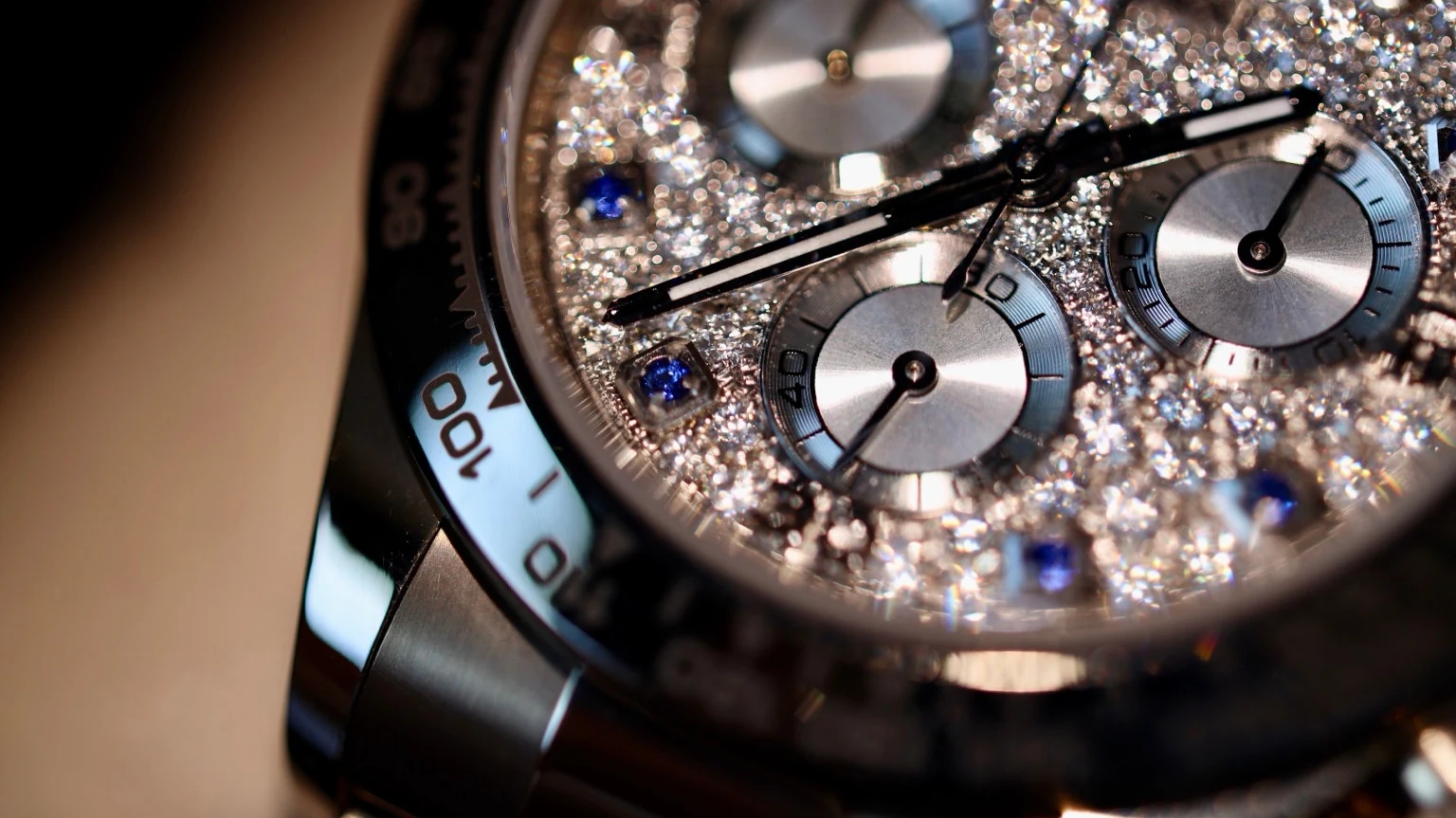 Detailed photograph of a custom stone-set chronograph dial with blue hour markers